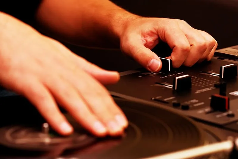DJ using a crossfader and scratching a vinyl record.