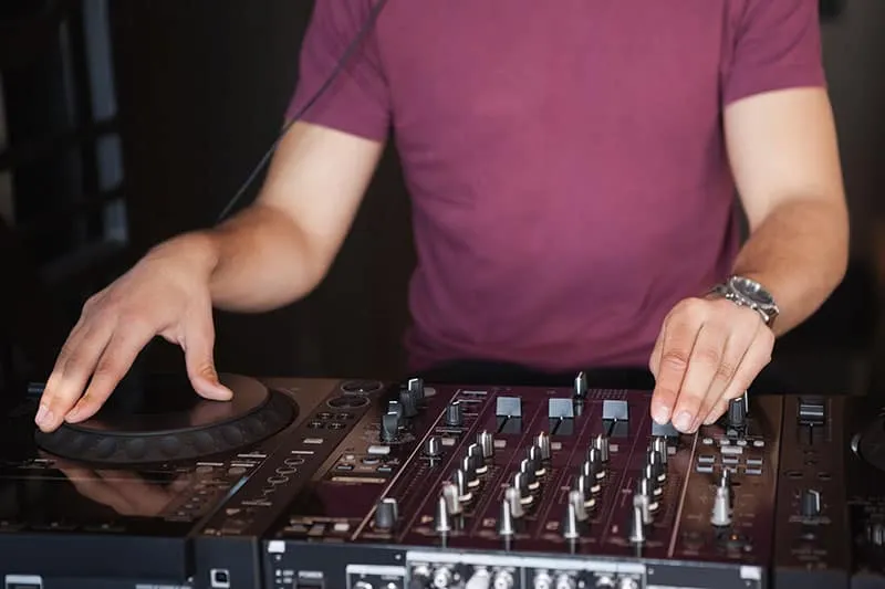 DJ standing in front of a DJ equipment