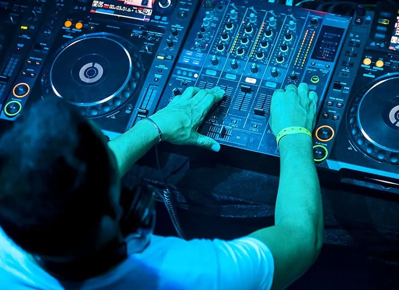 DJ adjusting sliders on DJ equipment
