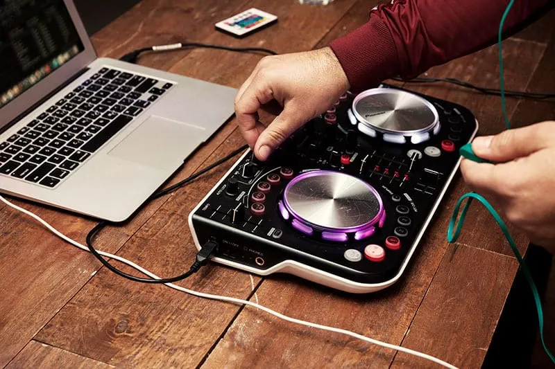 A photo of a DJ mixing on an entry-level controller.