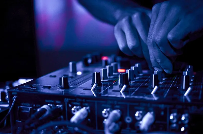 DJ using the EQs on a DJ mixer.