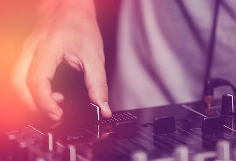 DJing using a crossfader on a DJ controller.