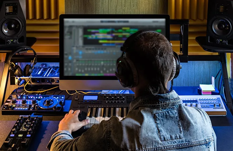 Music producer working on a song in his home studio.