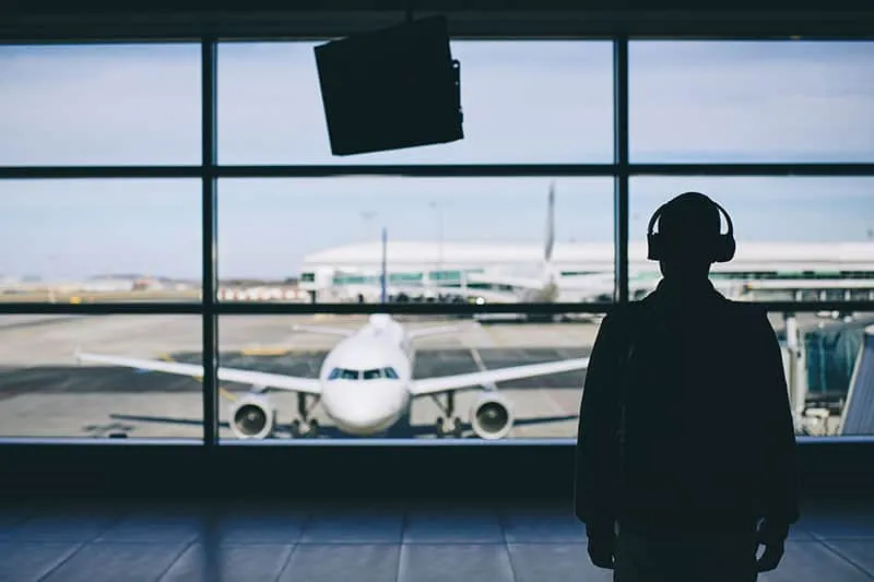Silhouette of a man with headphones at an airport
