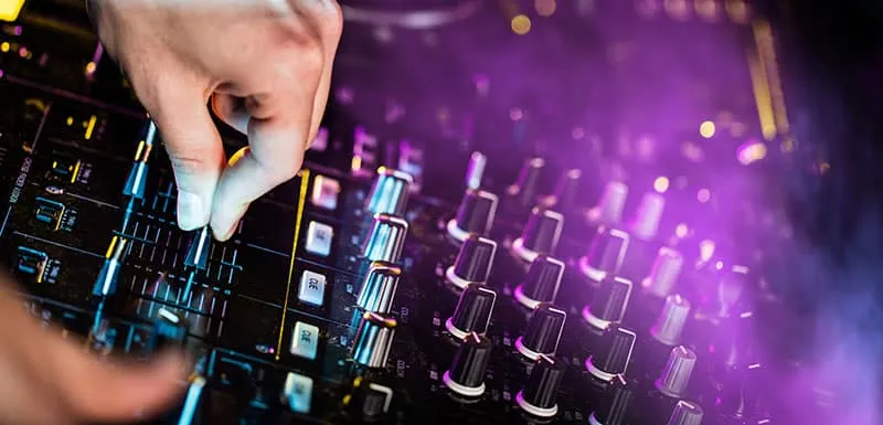 DJ adjusting the EQ on a DJ controller.