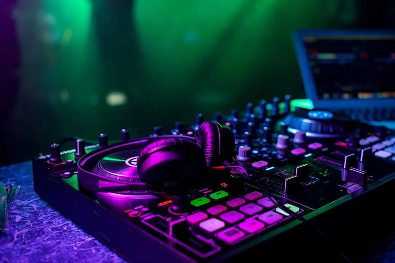 DJ headphones sitting on top of DJ equipment in a nightclub
