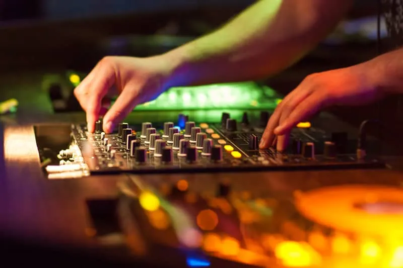 DJ adjusting controls on a DJ mixer