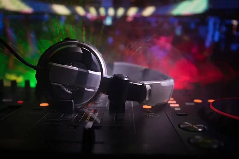 Headphones sitting on top of DJ equipment.