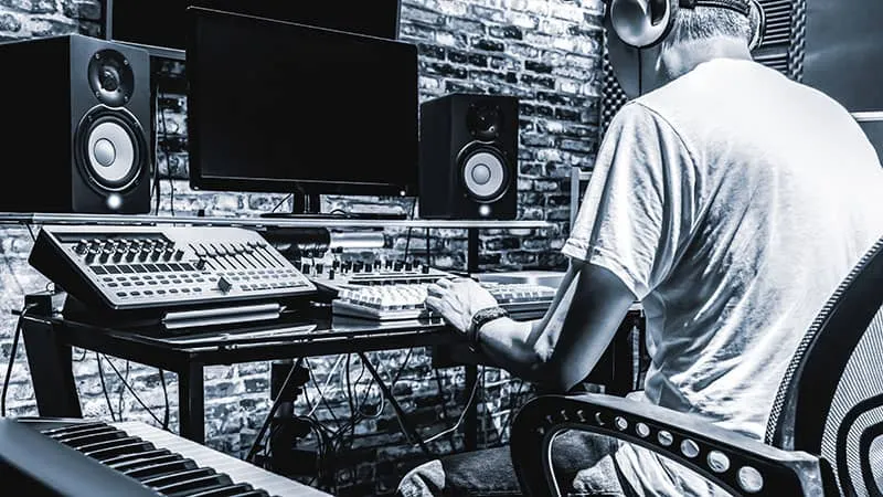 Black and white photo of a man in a home studio.