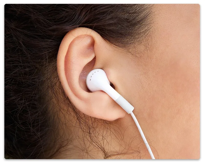 Side profile view of a women wearing earbuds.