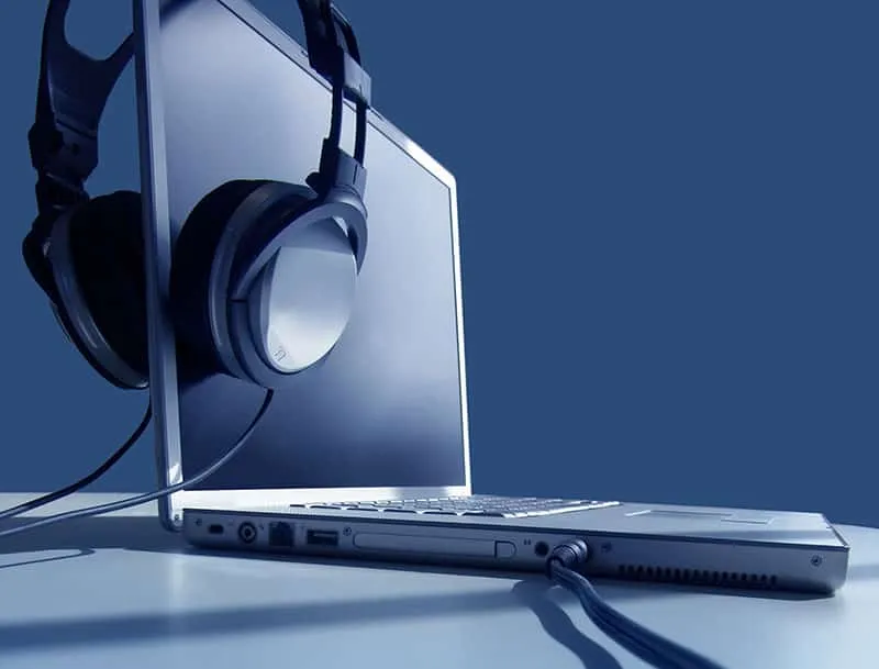 Picture of headphones hanging off a laptop.