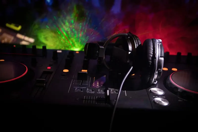 Headphones sitting on Dj equipment with a dark background