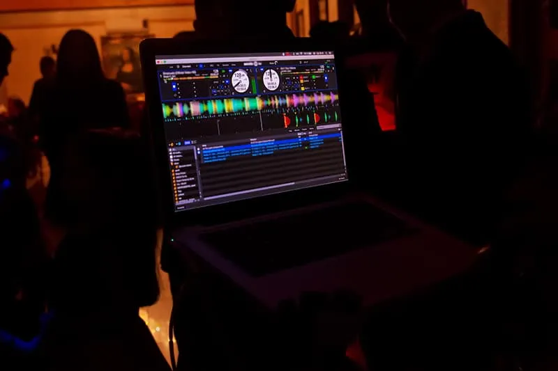 A DJ preparing a mix on a laptop.