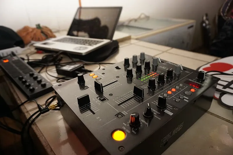 DJ equipment with a laptop in the background.