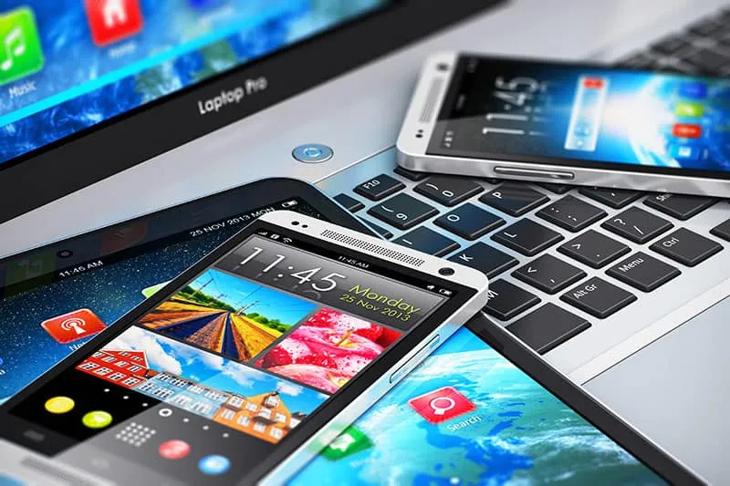 Assorted electronics including a laptop, cell phones and tablet.