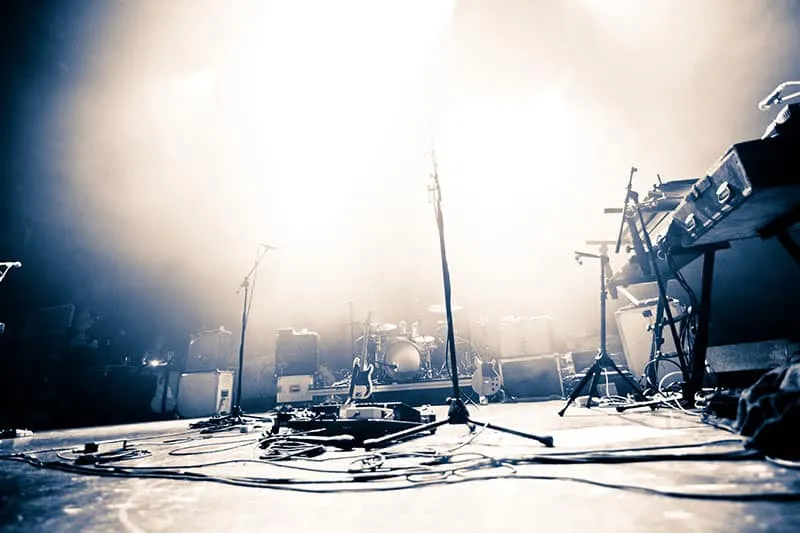 Illuminated stage with music equipment.