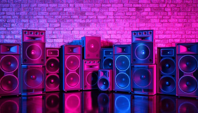 An assortment of PA speakers on a stage.