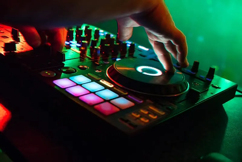 DJ playing at a party with a DJ controller.