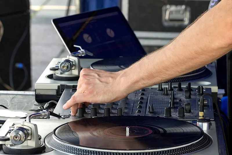 DJ using turntables and a laptop.