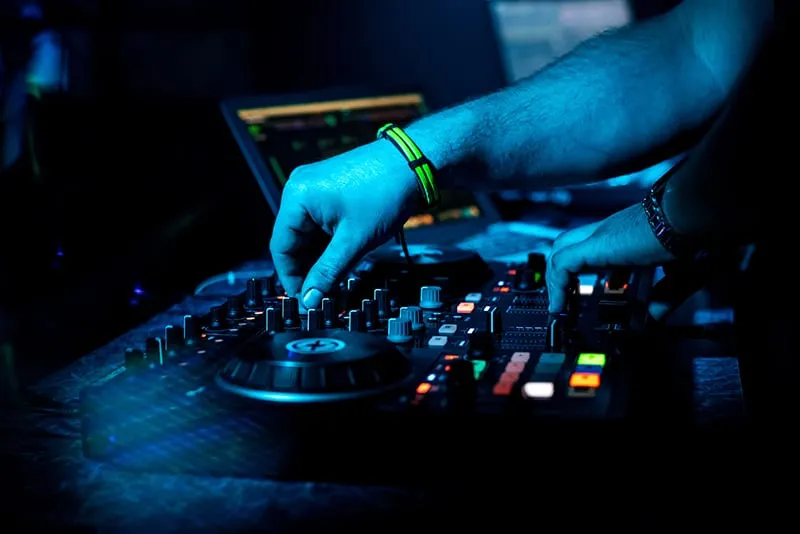 DJ performing with a DJ controller and laptop.