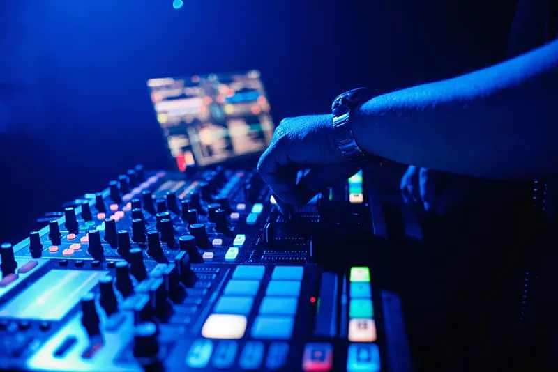 Native Instruments DJ gear at a nightclub with a DJ mixing.