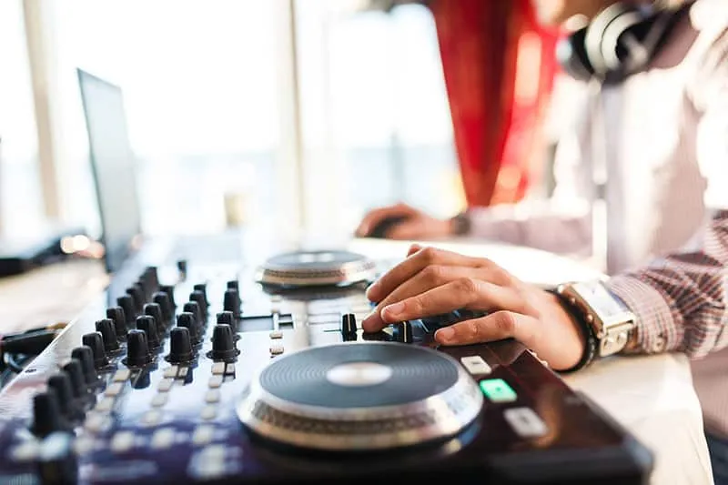 DJ working on his laptop and DJ controller.
